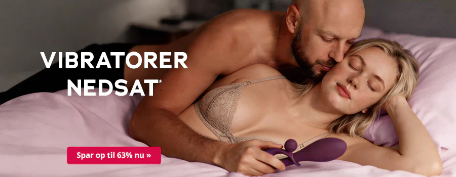 En mand med skæg ligger med bar overkrop bag en kvinde i en blonde-bh i en seng med et lyserødt tæppe. Kvinden holder en lilla vibrator i hånden. I midten står der med hvid skrift: »Vibratorer på tilbud«. Under teksten er der en rød knap med hvid skrift: »Spar op til 63 % nu«.