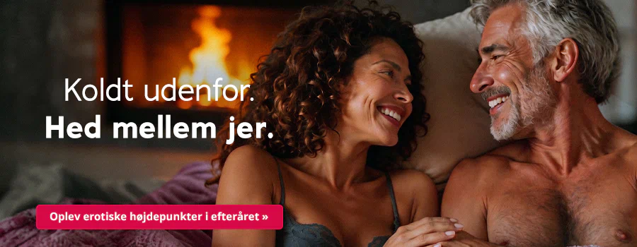 Et par ligger tæt sammen i sengen og smiler til hinanden. Til venstre en kvinde i en blonde-bh med mørke krøller, til højre en mand med bar overkrop, gråt hår og skæg. Tekst: "Koldt udenfor. Hedt mellem jer." Rød knap: "Oplev erotiske højdepunkter i efteråret".