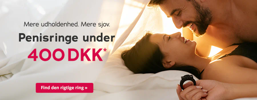 Et smilende par ligger tæt sammen i sengen og ser på hinanden. Kvinden holder en sort penisring i hånden. Til venstre står teksten »Mere udholdenhed. Mere sjov. Penisringe under 400 DKK*« med en rød knap »Find den rigtige ring«.