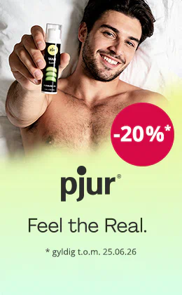 En smilende, bar overkrop mand ligger på en hvid baggrund og holder en flaske pjur-gel op mod kameraet. En rød cirkel viser „-20 %“. Tekst: „pjur – Feel the Real.“ og „gyldigt til 25.06.26“.